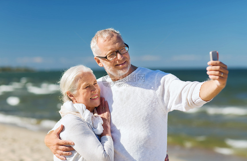 家庭,龄,旅行,技术人的快乐的老夫妇与智能手机自拍拥抱夏季海滩图片