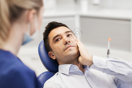 人,医学,口腔科保健男牙痛患者向牙科诊所办公室的女牙医抱怨图片