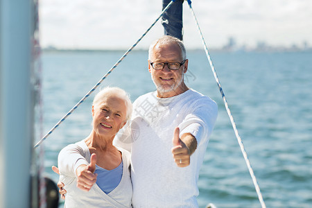 航海,龄,旅游,旅游人的快乐的老夫妇拥抱帆船游艇甲板上漂浮,并海上竖大拇指图片