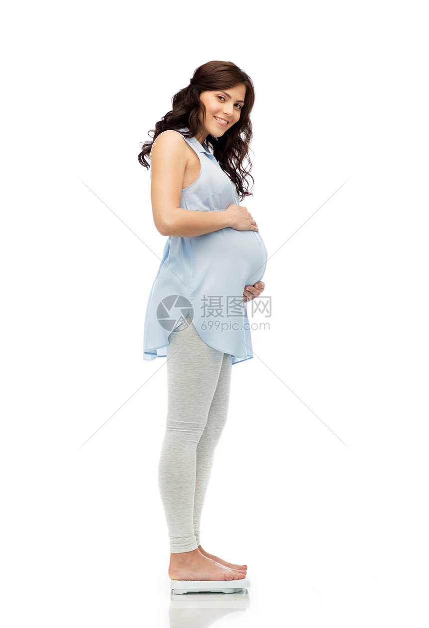 怀孕,保健人们的快乐孕妇测量体重的秤白色背景图片