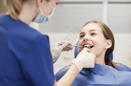 人,医学,口腔科保健快乐的女牙医与镜子检查病人女孩牙齿牙科诊所办公室背景图片