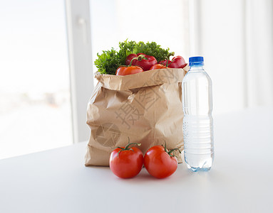 烹饪,饮食,素食健康饮食纸袋与新鲜成熟多汁的蔬菜水瓶厨房的桌子家里图片