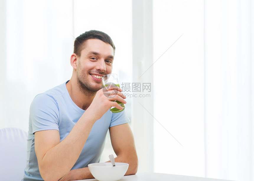 健康的生活方式微笑快乐的男人家里吃早餐,喝绿色果汁冰沙快乐的人家吃早餐图片
