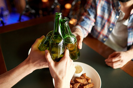 人,男人,休闲,友谊庆祝亲密的男朋友酒吧酒吧喝啤酒叮当的瓶子背景图片