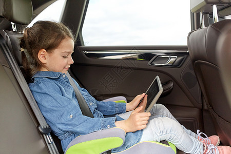交通,公路旅行,旅游,技术人的快乐的小女孩与平板电脑驾驶汽车安全座椅图片