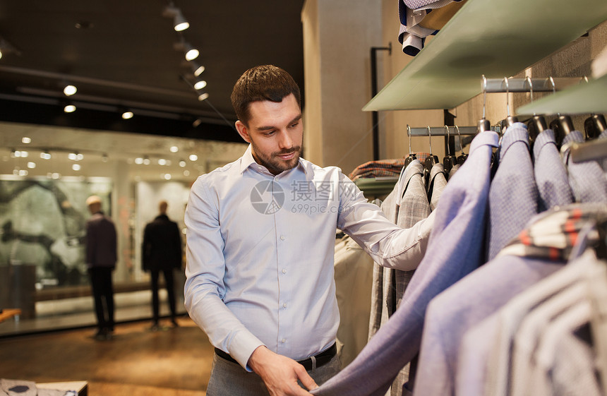 销售,购物,时尚,风格人的快乐的轻人穿着衬衫选择夹克商场服装店图片