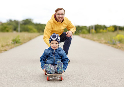 滑板小孩家庭,童,父亲,休闲人的快乐的父亲小儿子骑滑板背景