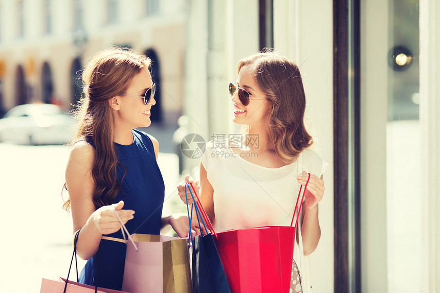 销售,消费主义人的快乐的轻妇女与购物袋交谈商店窗口城市图片