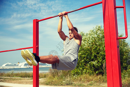 健身,运动,锻炼,训练生活方式的轻人夏季公园的水平杆上腹部运动图片