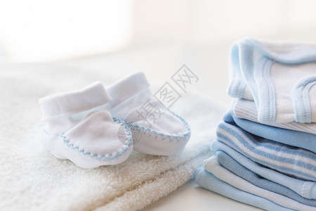服装,婴儿,母亲象白色婴儿靴,毛巾堆新生男孩的衣服图片