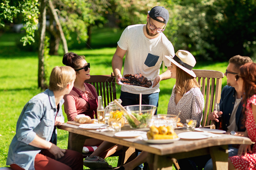 休闲,假期,饮食,人食物的快乐的朋友夏季花园聚会上吃肉图片