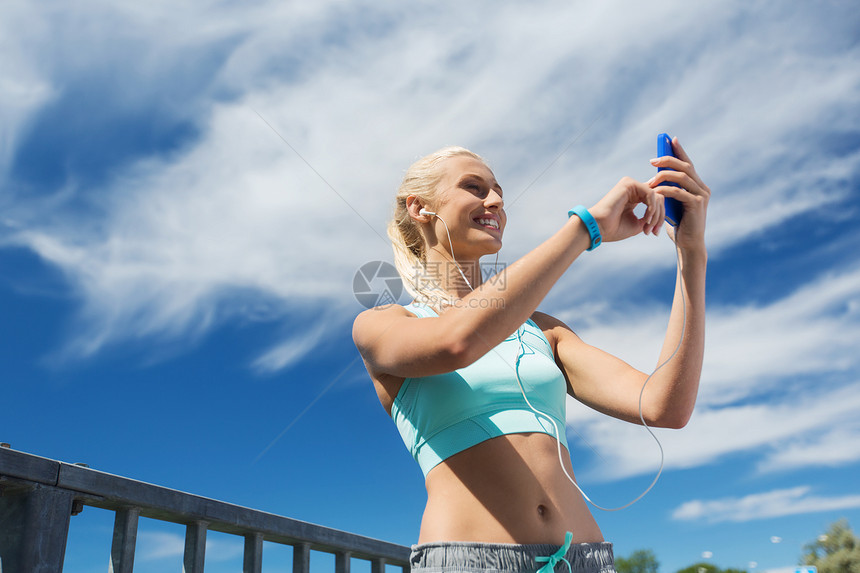 健身,运动,人,技术健康的生活方式微笑的轻妇女与智能手机耳机听音乐户外锻炼图片