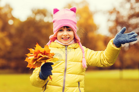 无忧无虑的少者秋天,童,幸福人的快乐美丽的小女孩与枫叶挥动手户外背景