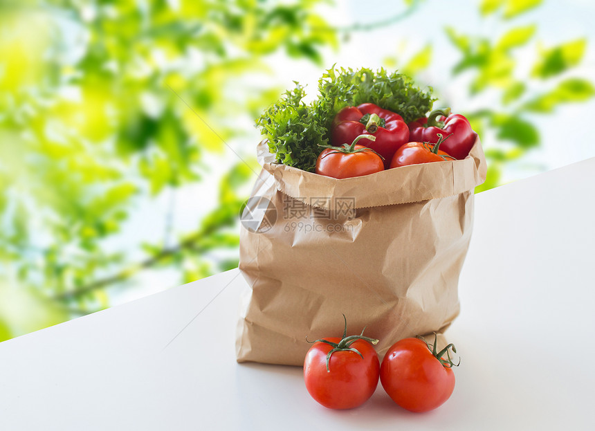 烹饪,饮食,素食健康饮食纸袋与新鲜成熟多汁的蔬菜绿色的桌子上的绿色自然背景图片