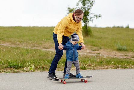 家庭,童,父亲,休闲人的快乐的父亲教小儿子骑滑板高清图片