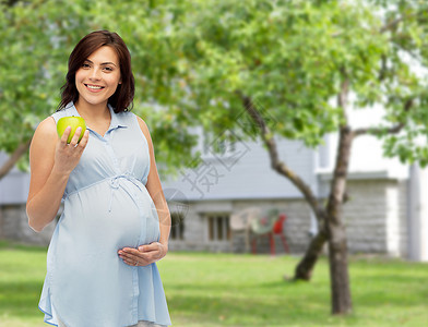 怀孕,健康饮食,食物人的快乐的孕妇抱着绿色的苹果夏天的花园房子背景图片