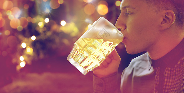 人,饮料,酒精休闲近距离的轻人喝啤酒璃杯假日灯光背景图片