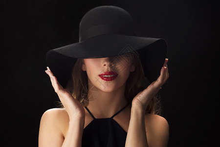 人,奢侈时尚的美丽的女人戴着黑色的帽子黑暗的背景图片