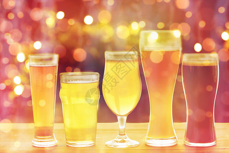 啤酒厂,饮料酒精同的啤酒桌子上的假期灯光背景把同的啤酒放桌子上的眼镜里背景图片