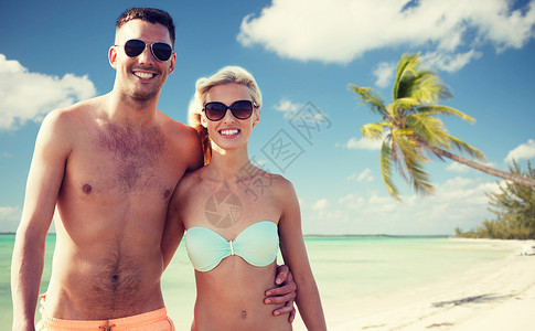 爱情,旅行,旅游,夏天人的微笑的夫妇度假的泳装太阳镜拥抱热带海滩背景图片