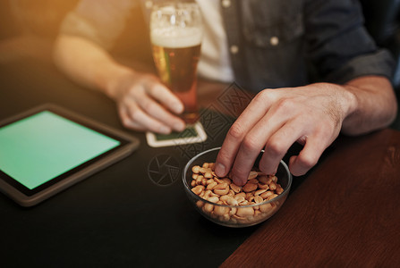 人,休闲技术的密切的人与平板电脑电脑喝啤酒吃花生酒吧酒吧图片