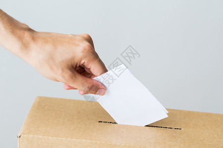 投票,公民权利人民男手把他的选票投选举的投票箱里背景