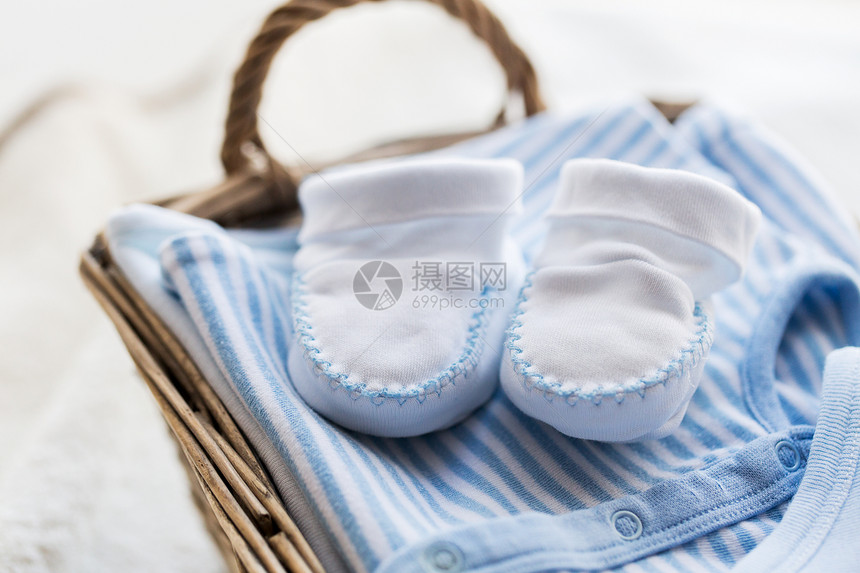 服装,婴儿,母亲象白色婴儿靴与堆衣服毛巾为新生男孩篮子桌子上图片