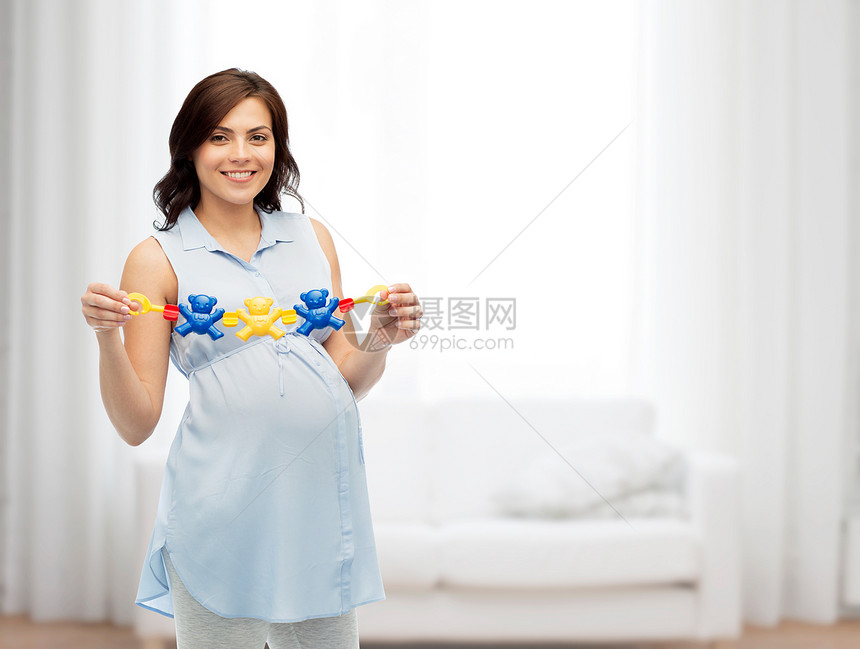 怀孕,母亲,人期望的快乐的孕妇着拨浪鼓玩具家里的客厅背景图片