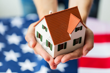 特写镜头美国人公民身份住所财产房地产人的手握美国上的客厅模型背景