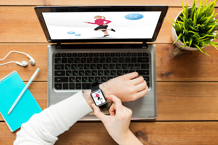 运动,人技术妇女智能手表与健身应用屏幕笔记本电脑木桌上图片