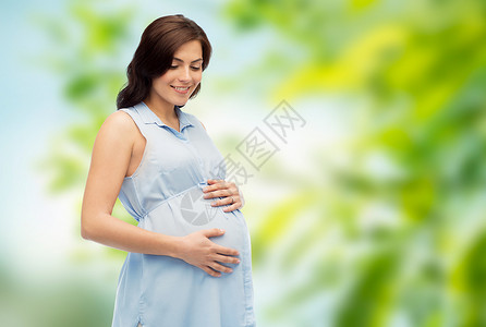 怀孕,母亲,人期望的快乐的孕妇触摸她的大肚子绿色的自然背景图片