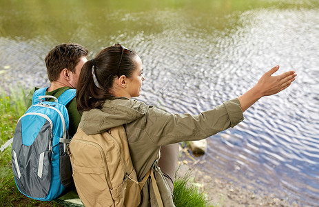 旅行,徒步旅行,背包旅行,旅游人的夫妇背包坐湖边河岸图片
