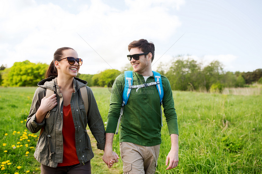 旅行,徒步旅行,背包旅行,旅游人们的快乐的夫妇,背包牵着手,沿着乡间道路走户外图片