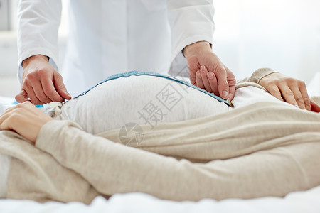怀孕,医学,保健人们的密切产科医生与厘米磁带测量孕妇肚子医院图片