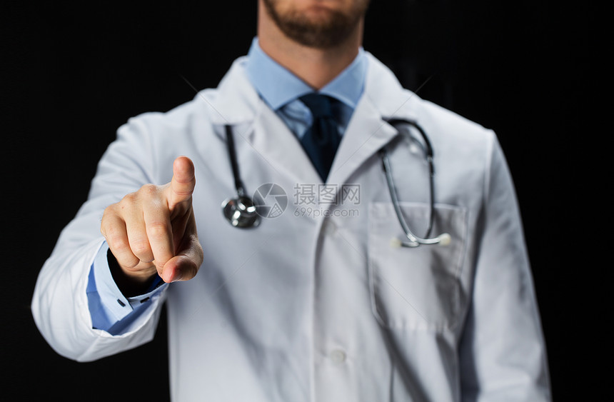 医疗保健人职业医学穿着白色外套的男医生用听诊器黑色背景的黑色背景图片
