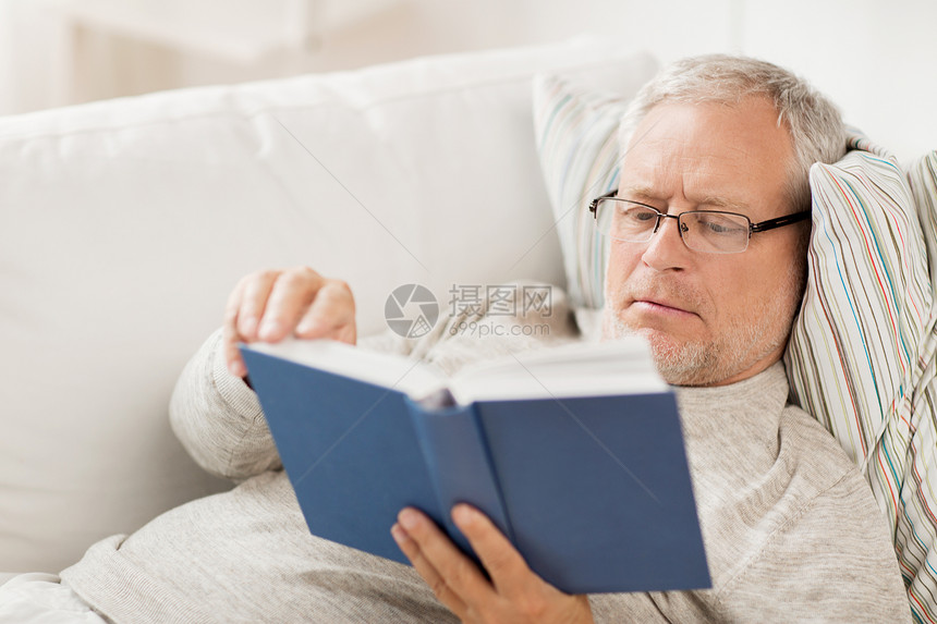 龄休闲人的老人躺沙发上,家看书图片