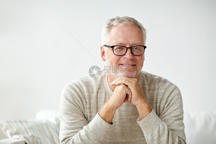 老,舒适人的微笑的老人戴着眼镜坐家里的沙发上图片