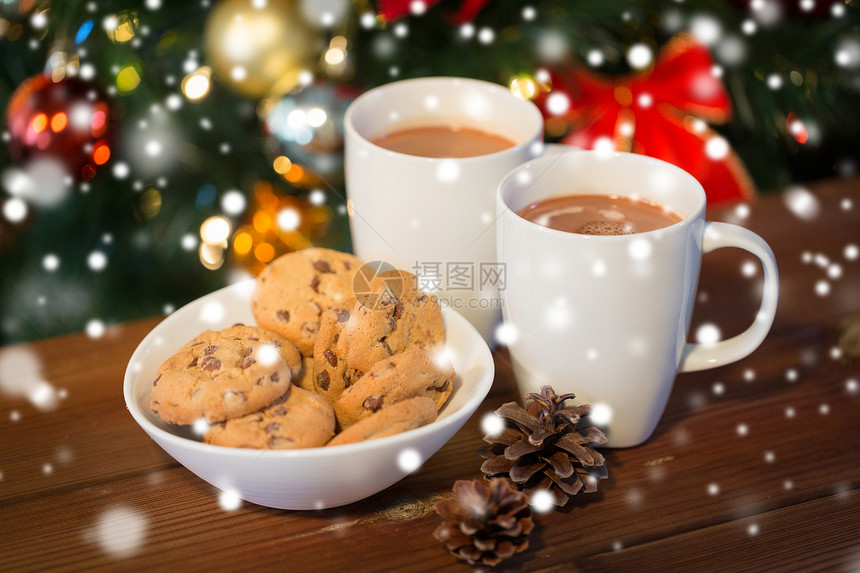 假日,冬天,食物饮料的燕麦片饼干,杯子与热巧克力可可饮料松果木制桌子上的诞树背景图片