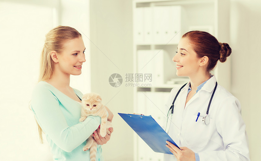 医学,宠物,动物,保健人的快乐的女人抱着苏格兰折叠小猫兽医医生与剪贴板兽医诊所图片