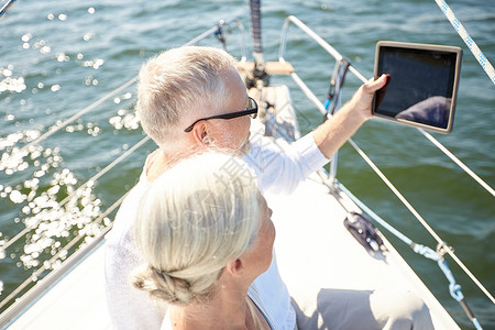 航海,技术,旅游,旅游人的老夫妇与平板电脑帆船游艇甲板漂浮海上图片