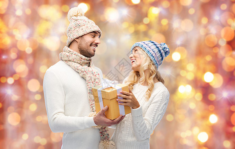 冬天,假期,夫妇,诞节人们的微笑的男人女人戴着帽子围巾,背景上礼品盒图片
