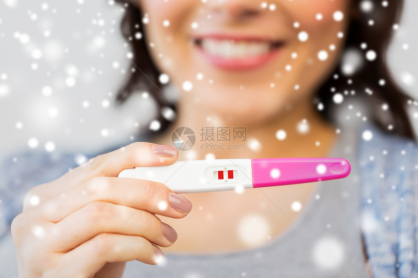 怀孕,生育,冬季人的接近快乐的女人与阳的家庭怀孕测试雪图片