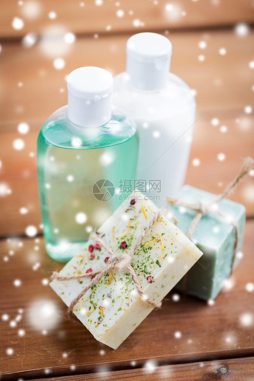 美容,水疗,身体护理,浴缸天然化妆品手工肥皂棒洗液瓶木制桌子上的雪图片
