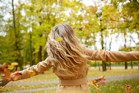 季节人们的快乐的轻女人秋天的公园里树叶玩快乐的女人秋天的公园里玩树叶图片