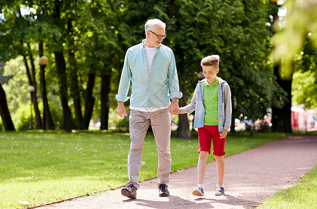 家庭世代交流人的快乐的祖父孙子夏季公园散步图片