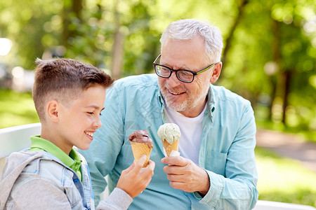 男孩卖冰淇淋家庭世代交流人的快乐的祖父孙子夏天的公园吃冰淇淋背景