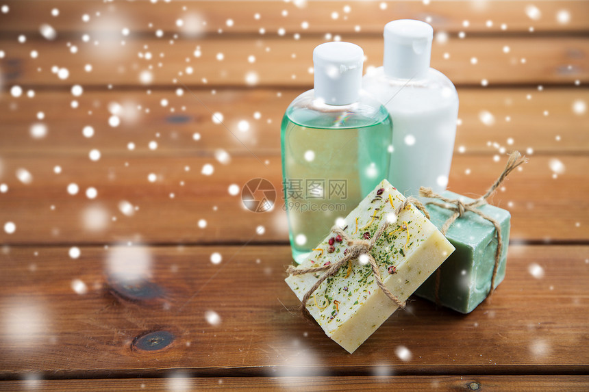 美容,水疗,身体护理,浴缸天然化妆品手工肥皂棒洗液瓶木制桌子上的雪图片