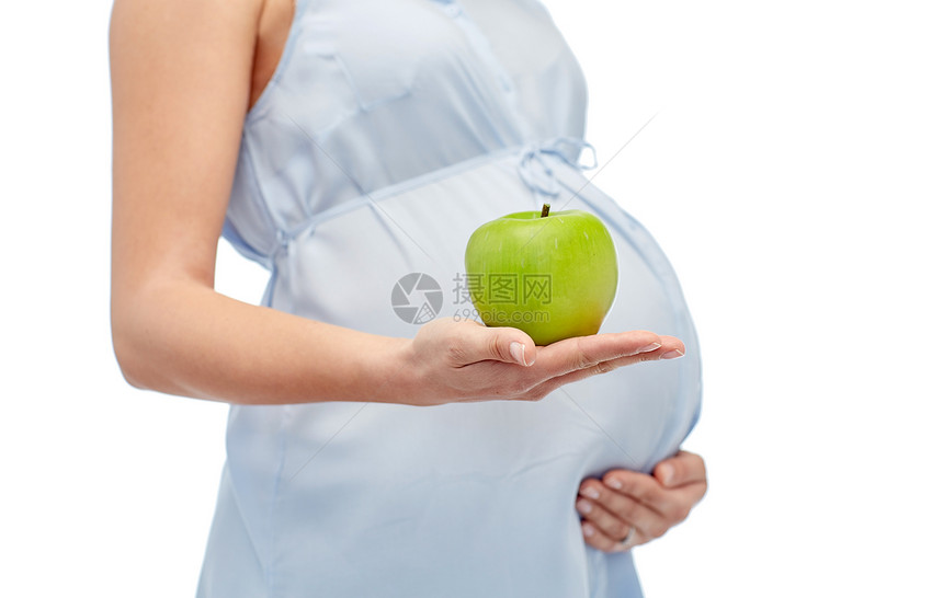 怀孕,健康饮食,食物人的密切孕妇持绿色苹果白色背景图片
