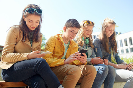技术,互联网人的群快乐的青少朋友与智能手机耳机户外图片