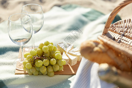 食物,假日,庆祝夏季野餐篮子与葡萄,酒杯奶酪海滩上背景图片